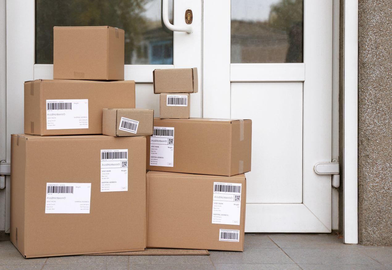 Paket auf Fußmatte vor Haustuer – ein Paketkasten verhindert unsichere Ablagen und schuetzt Lieferungen